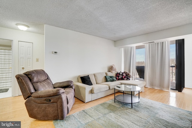 living room with a textured ceiling and light hardwood / wood-style floors