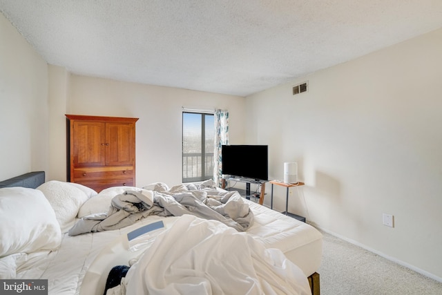 bedroom with a textured ceiling and carpet floors