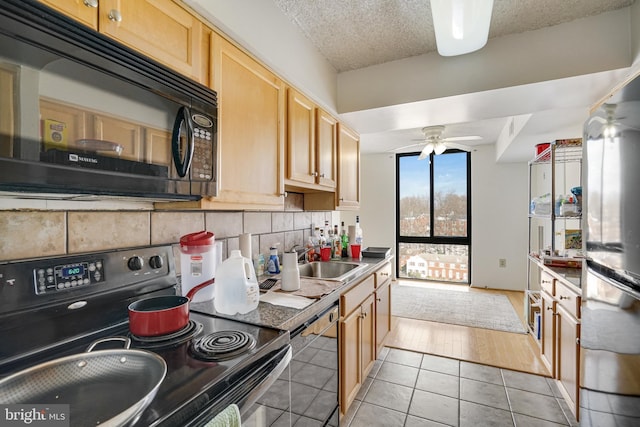 kitchen with ceiling fan, sink, decorative backsplash, light tile patterned floors, and black appliances