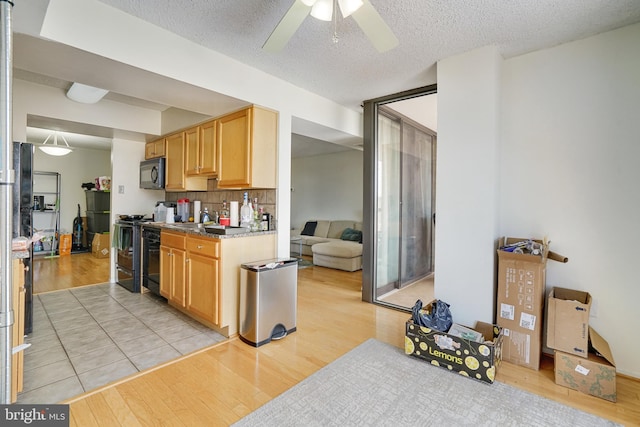 kitchen with tasteful backsplash, light hardwood / wood-style flooring, ceiling fan, and black appliances