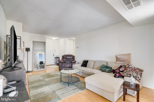 living room featuring a textured ceiling and light hardwood / wood-style floors