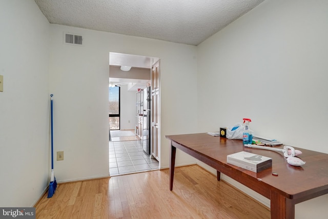 office area featuring a textured ceiling and light hardwood / wood-style floors