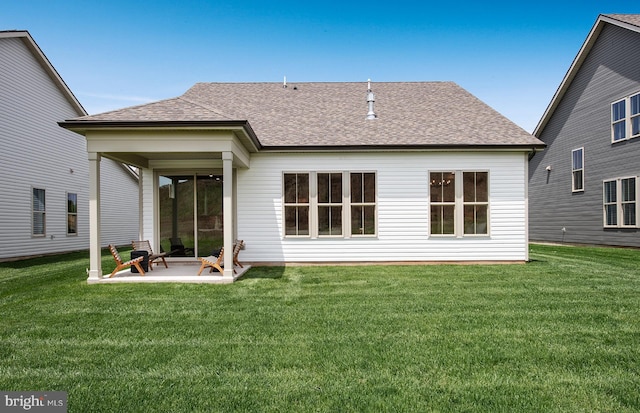 rear view of property featuring a yard and a patio area