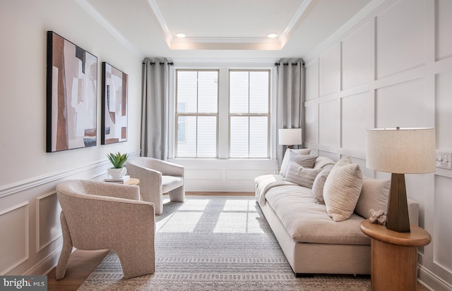 living room with a tray ceiling, hardwood / wood-style flooring, and ornamental molding