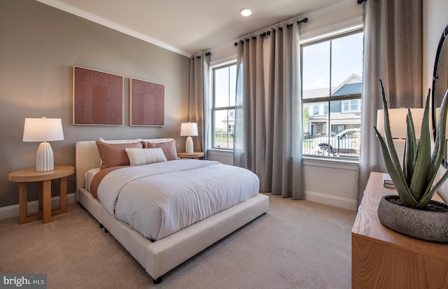 bedroom with crown molding and light carpet