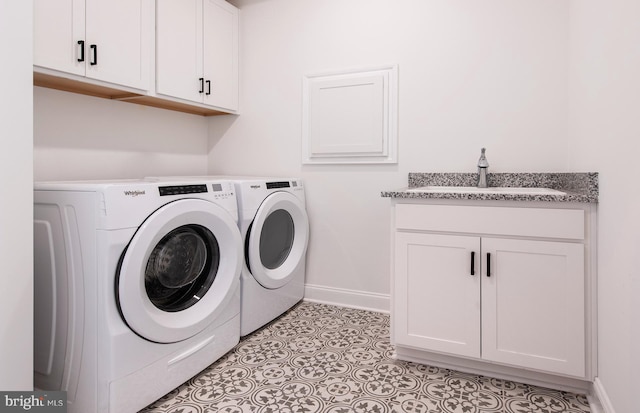 laundry room featuring cabinets, light tile patterned floors, washer and dryer, and sink