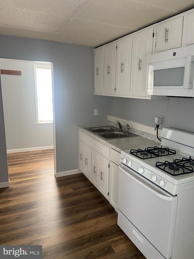 kitchen featuring a drop ceiling, white appliances, dark wood-type flooring, sink, and white cabinetry