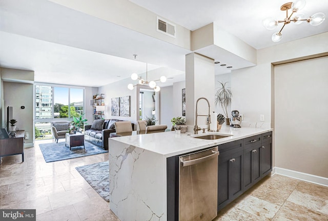 kitchen with light stone counters, stainless steel dishwasher, floor to ceiling windows, sink, and hanging light fixtures