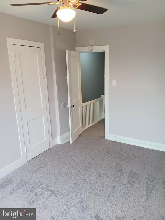 unfurnished bedroom featuring ceiling fan and carpet floors