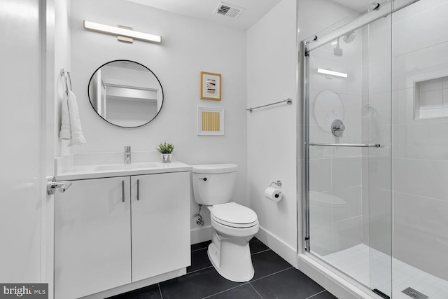 bathroom with tile patterned floors, vanity, toilet, and walk in shower