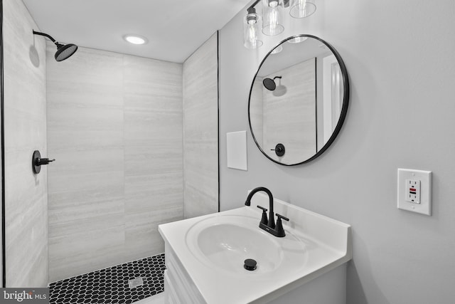 bathroom with a tile shower and sink