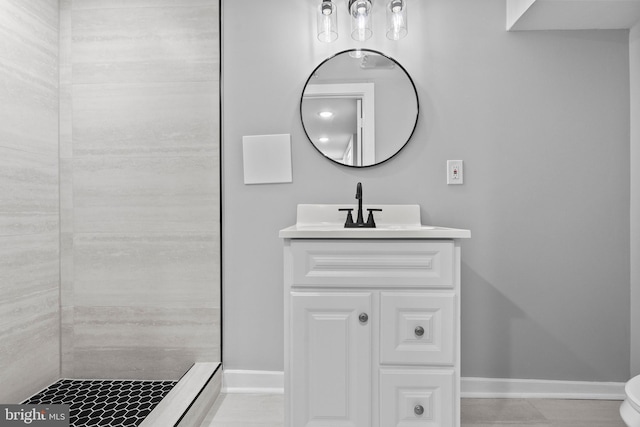 bathroom with vanity, toilet, and tiled shower