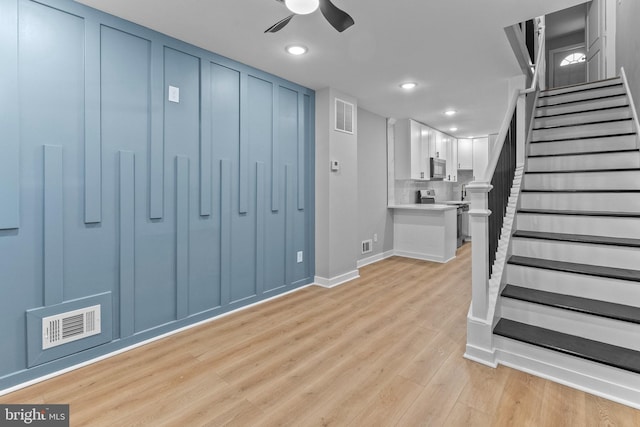 basement with light wood-type flooring and ceiling fan