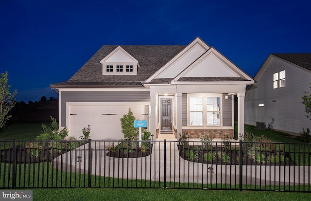 view of front of house featuring covered porch, a garage, central air condition unit, and a lawn