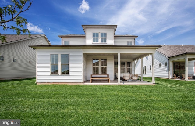 back of property featuring a lawn and a patio