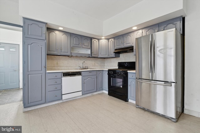 kitchen with tasteful backsplash, sink, black range, dishwasher, and stainless steel refrigerator