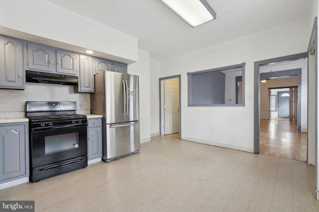 kitchen featuring gray cabinetry, light hardwood / wood-style flooring, ceiling fan, black gas range oven, and stainless steel refrigerator