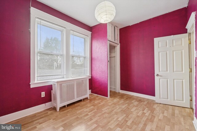 empty room featuring light hardwood / wood-style flooring and radiator