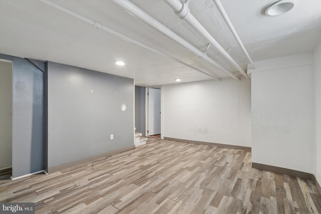 basement with light hardwood / wood-style floors