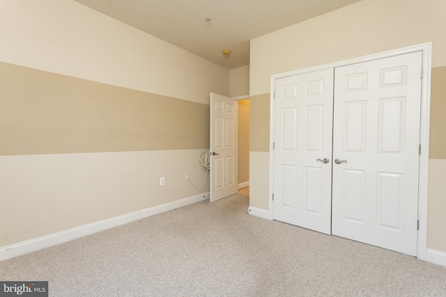 unfurnished bedroom with light carpet and a closet