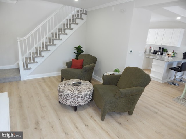 living area featuring ornamental molding and light hardwood / wood-style flooring