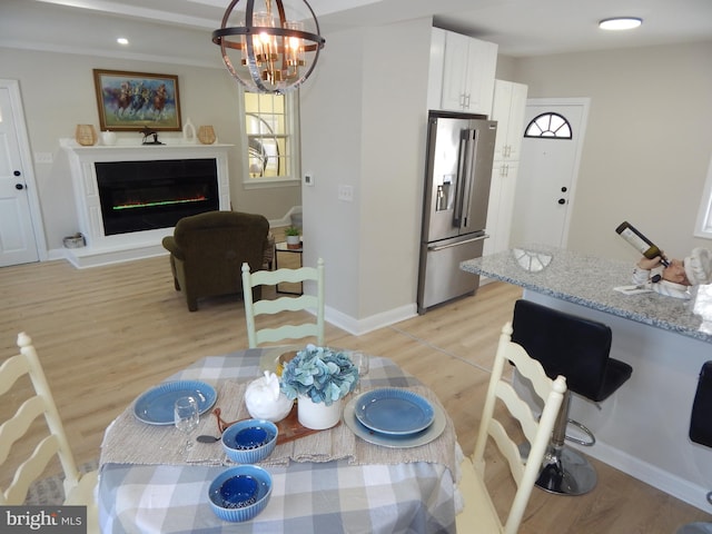 dining room with light hardwood / wood-style flooring and an inviting chandelier