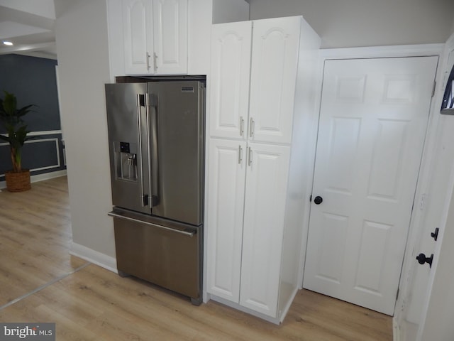 kitchen featuring white cabinets, light wood-type flooring, and stainless steel refrigerator with ice dispenser