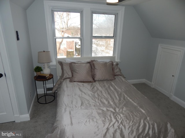 bedroom featuring light carpet and vaulted ceiling