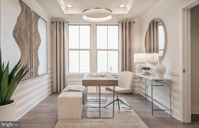 sitting room with a tray ceiling, plenty of natural light, and hardwood / wood-style flooring