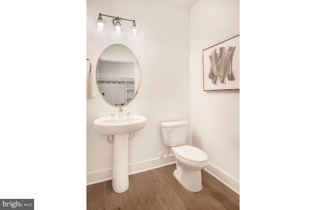 bathroom with hardwood / wood-style flooring and toilet