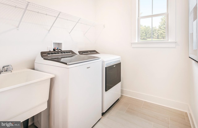 washroom featuring sink, light tile patterned floors, and independent washer and dryer