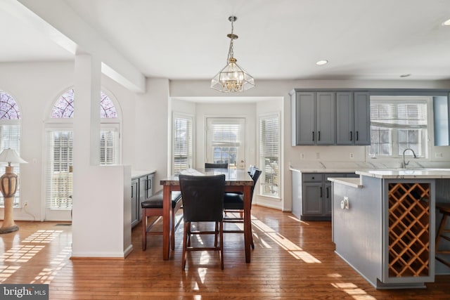 dining room with sink, dark wood-type flooring, and a chandelier