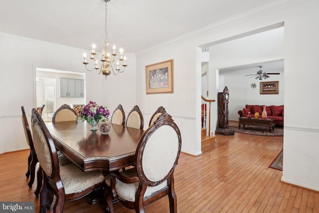 dining space featuring ceiling fan with notable chandelier, light hardwood / wood-style floors, and crown molding