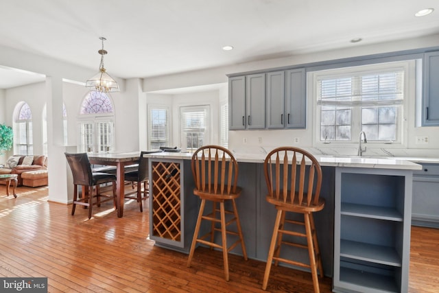 kitchen featuring pendant lighting, plenty of natural light, gray cabinets, and hardwood / wood-style floors