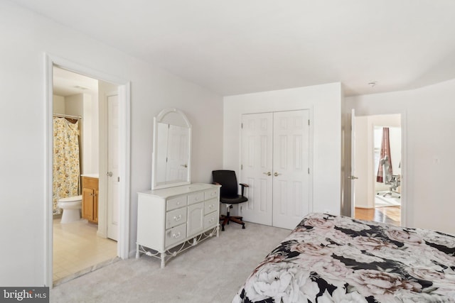 bedroom featuring light carpet, ensuite bath, and a closet