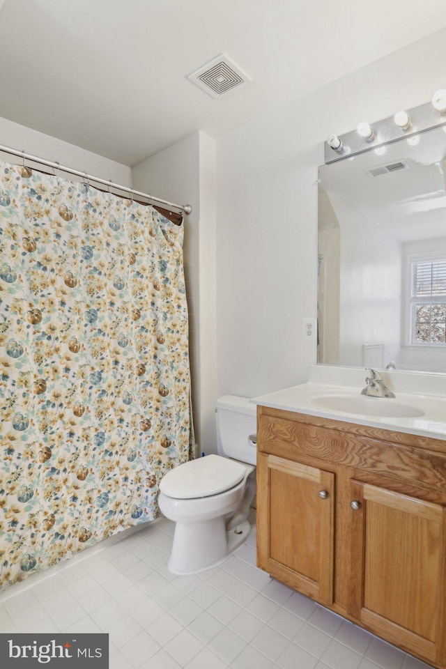 bathroom with tile patterned flooring, vanity, and toilet