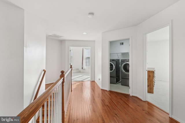 hall with washer and dryer and hardwood / wood-style flooring