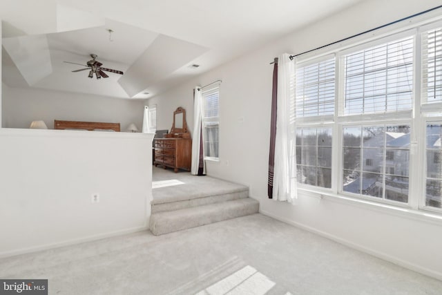 interior space with ceiling fan and a tray ceiling