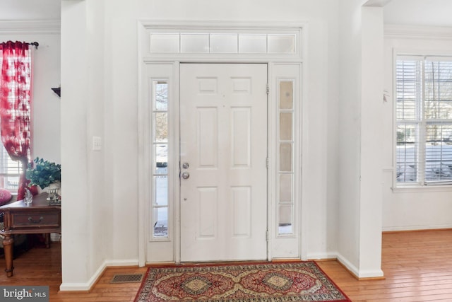 foyer entrance with hardwood / wood-style floors and ornamental molding