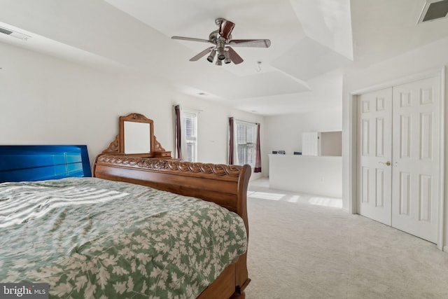 carpeted bedroom with a tray ceiling and ceiling fan