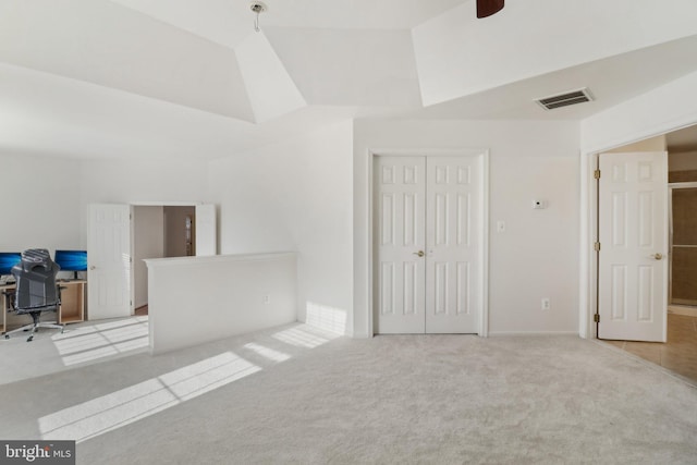 unfurnished bedroom featuring light colored carpet and vaulted ceiling