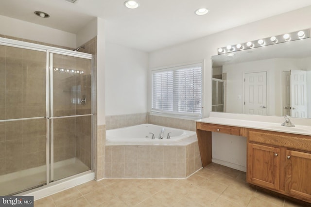 bathroom featuring shower with separate bathtub, vanity, and tile patterned floors