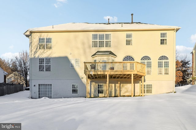 snow covered back of property featuring a deck