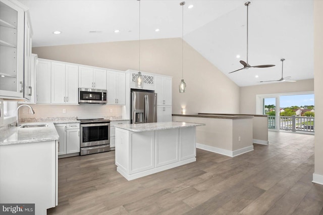 kitchen with white cabinetry, sink, a center island, pendant lighting, and appliances with stainless steel finishes