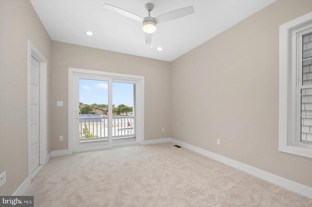 unfurnished room with ceiling fan and light colored carpet