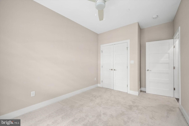 unfurnished bedroom with ceiling fan, a closet, and light colored carpet