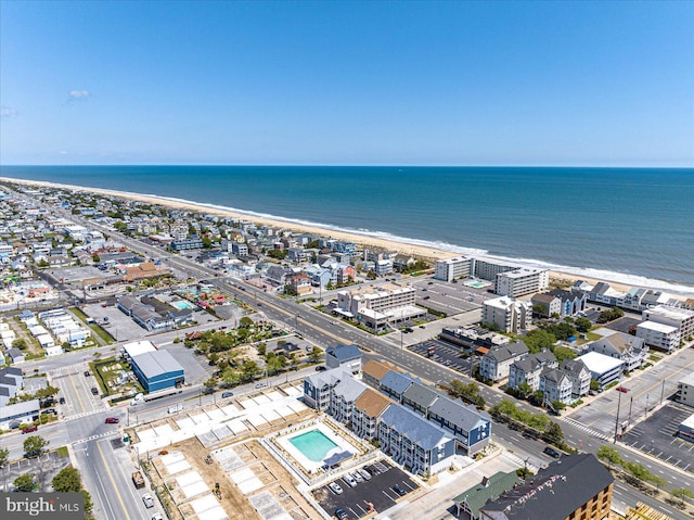 birds eye view of property with a water view and a beach view