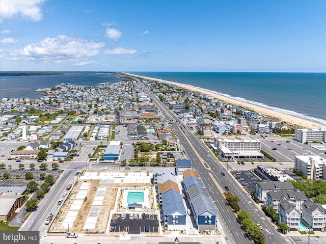 birds eye view of property with a water view and a beach view