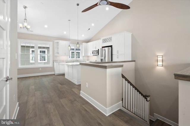 kitchen featuring white cabinets, high vaulted ceiling, decorative light fixtures, and appliances with stainless steel finishes