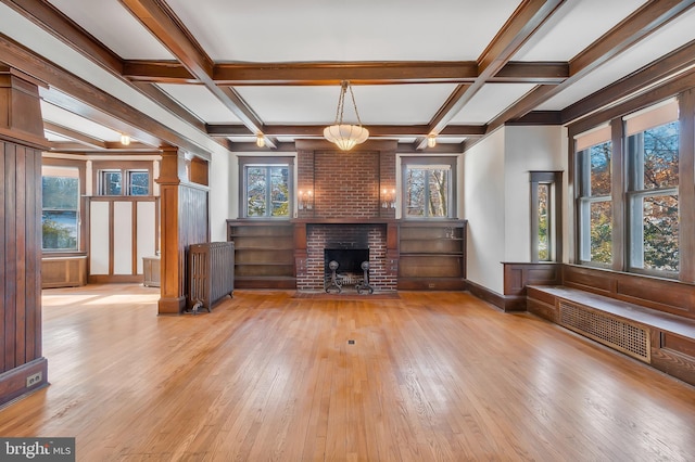 unfurnished living room with beamed ceiling, coffered ceiling, and a fireplace